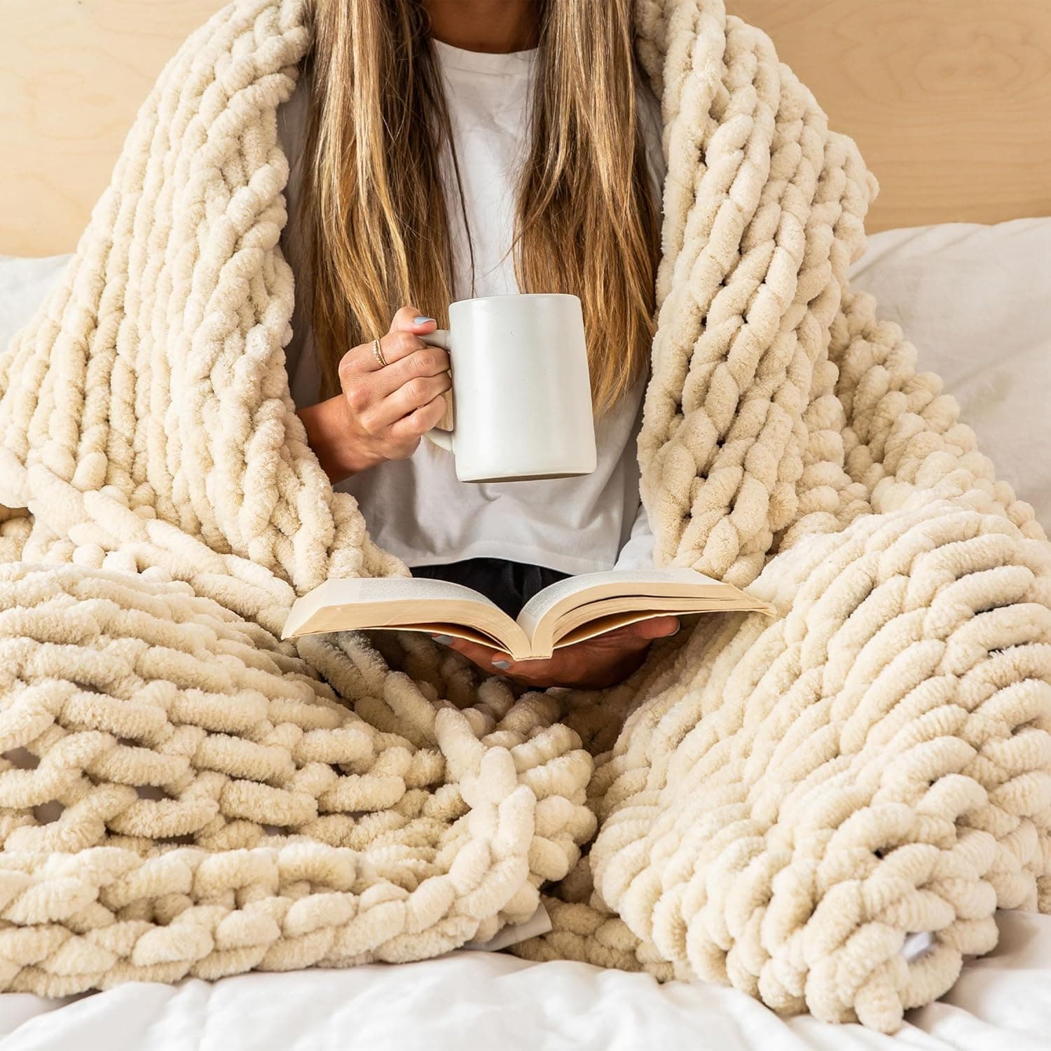 Buttercream chunky chenille knit throw blanket draped on a sofa