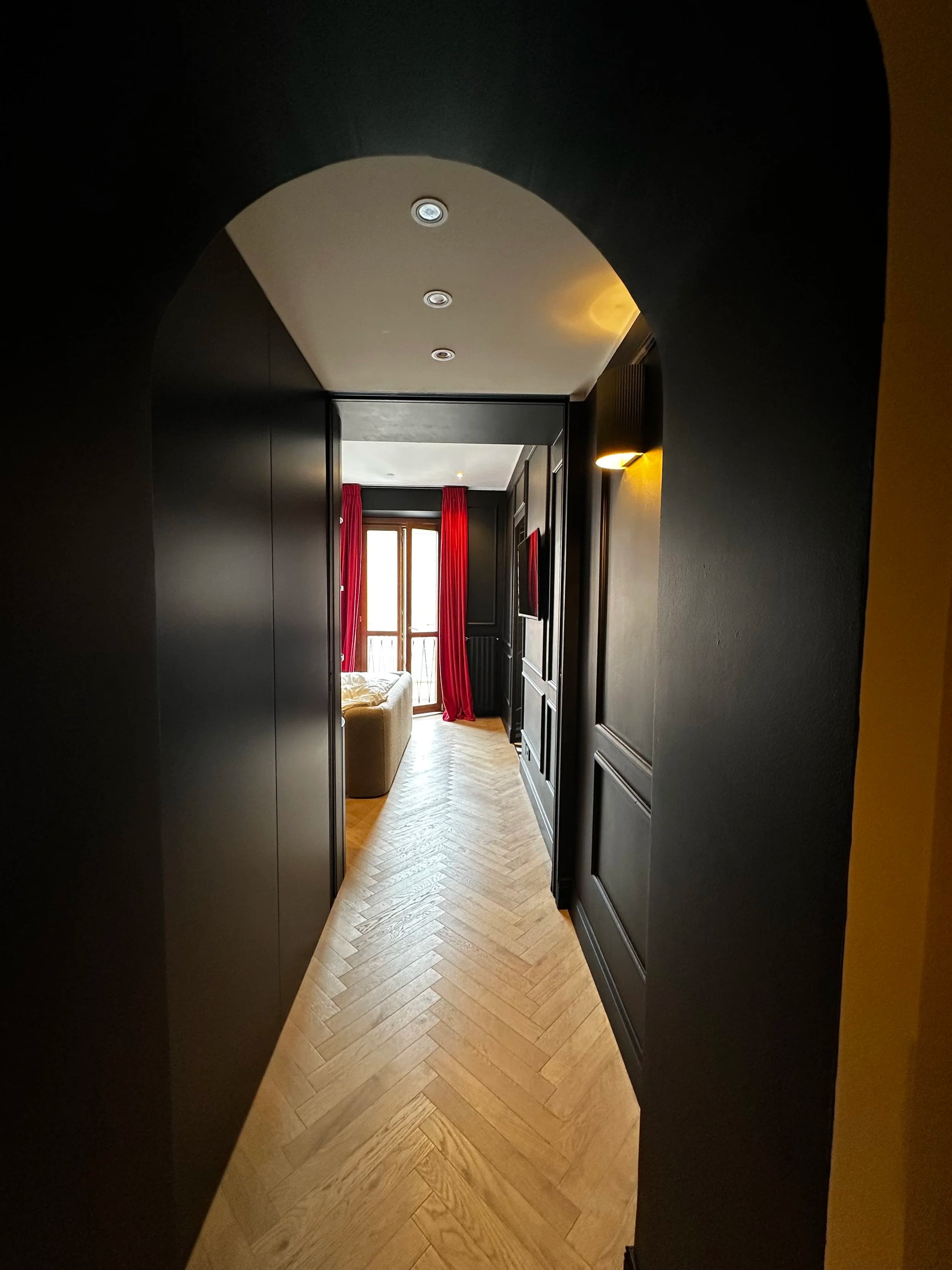 Milan Jewel hallway — herringbone marble floors, crimson silk curtains, gilded ceiling detail